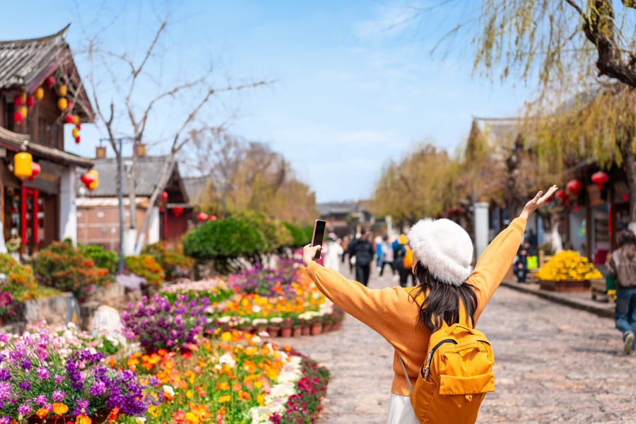 Turista tomandose una foto en un barrio tipico de Lijiang China
